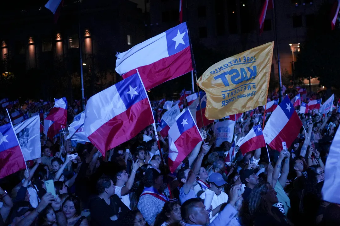 Simpatizantes del presidente de Chile, José Antonio Kast, agitan banderas previo a su discurso este miércoles.