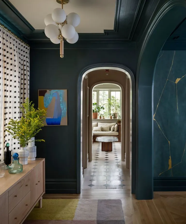 Este verde oscuro se utilizó en todo el vestíbulo de este comedor, pero con una variedad de acabados, incluyendo el color mate en las paredes, plano en el techo y semibrillantes en las maderas. Créditos: Aaron Leitz. Diseño: Jessica Helgerson Interior Design.
