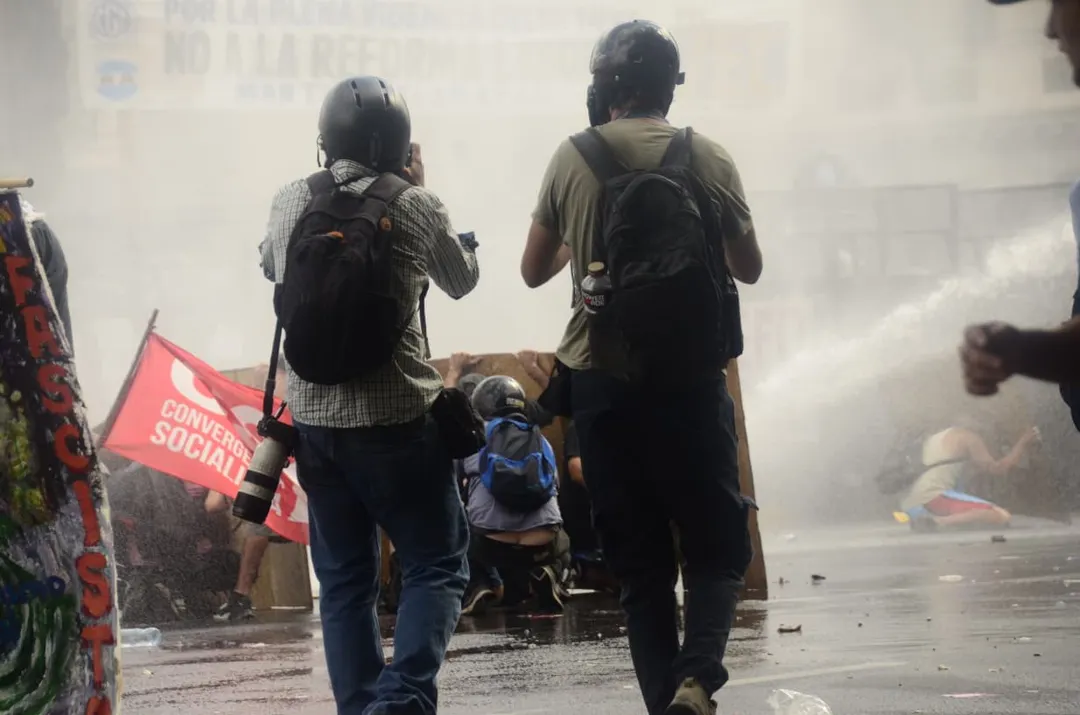 Reporteros gráficos cubriendo la marcha contra la reforma laboral.
