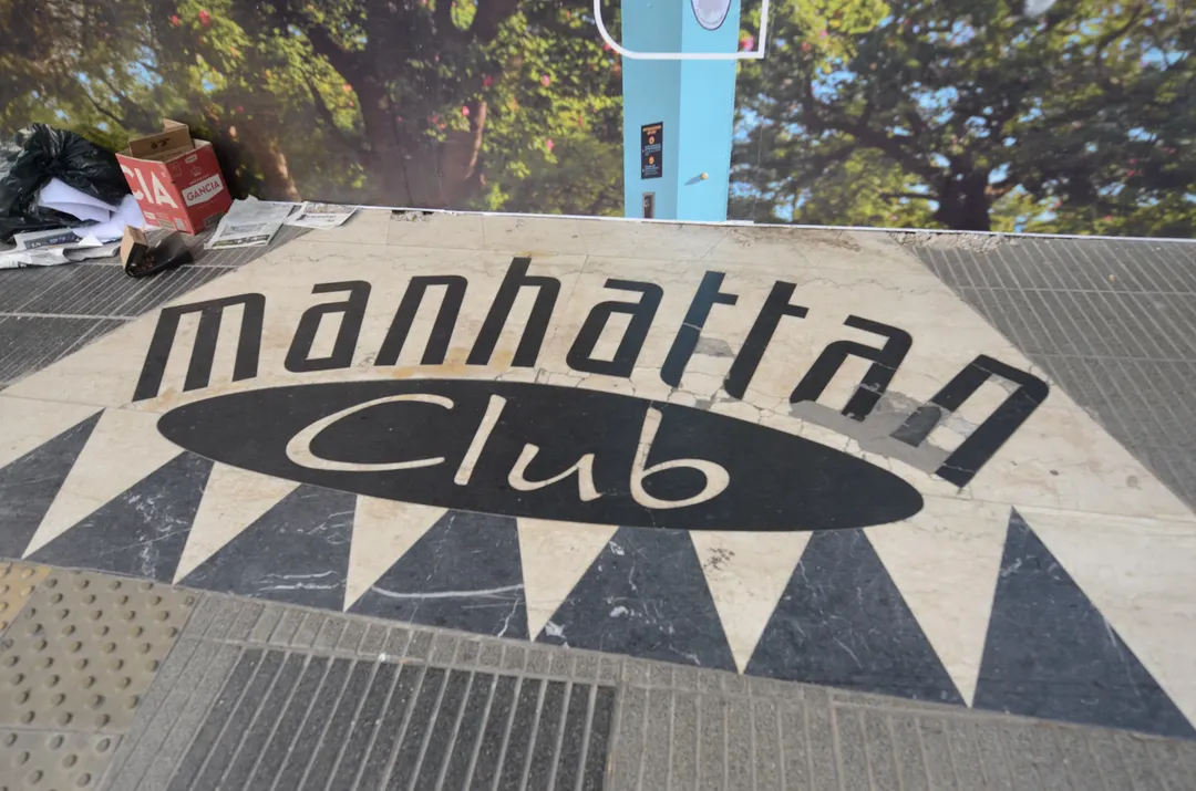 La entrada noventosa del Café Manhattan que espera por su destino incierto.