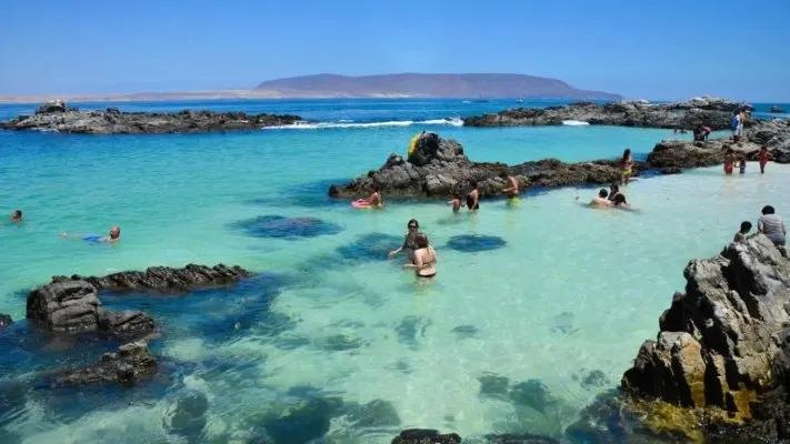 La arena clara y el mar calmo hacen de esta playa una de las más llamativos del norte chileno.