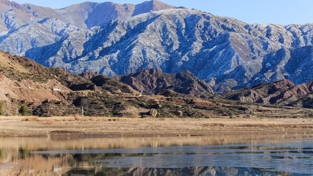 Parte del lago congelado y detrás se extiende la cordillera de Los Andes