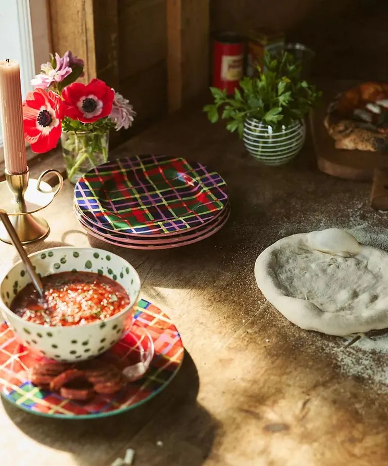 La estética del tartán trasciende las telas, como ocurre en esta mesa con los platos. Créditos: Anthropologie.