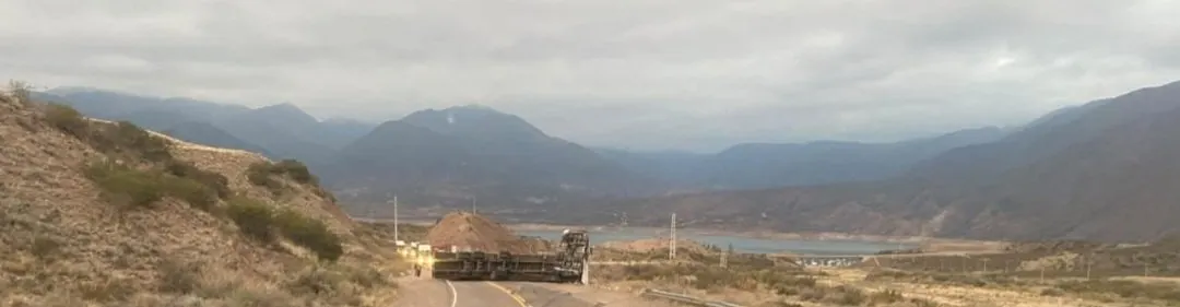 La impactante imagen del camión tendido sobre la Ruta 7 y el dique Potrerillos de fondo. 