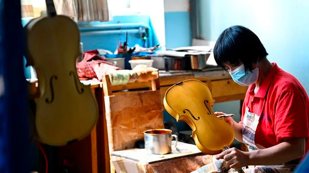 Un trabajador fabrica un violín en un taller de Queshan, en la provincia china de Henan.