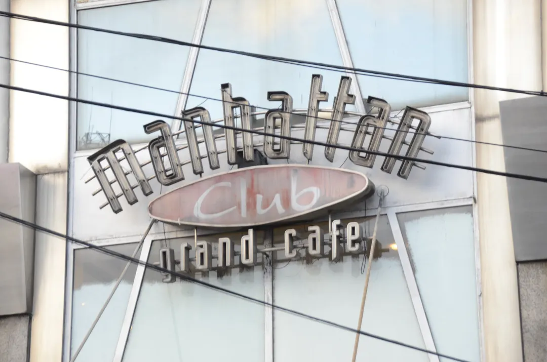El ya deslucido cartel del Café Manhattan que supo relucir en las noches de Belgrano