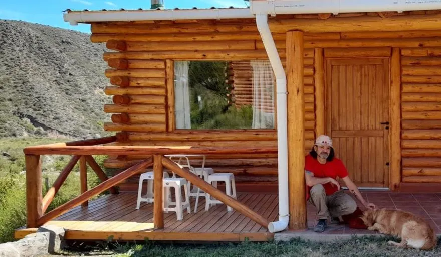 Daniel Piccolo junto a su perro Moro, en el complejo que construyó con sus manos.