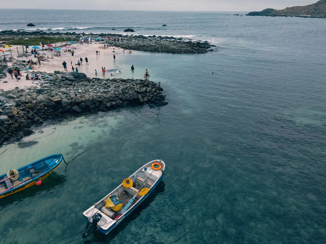La playa de Totoralillo combina arena blanca, aguas transparentes y un entorno rocoso que recuerda a destinos del Caribe en Chile.  