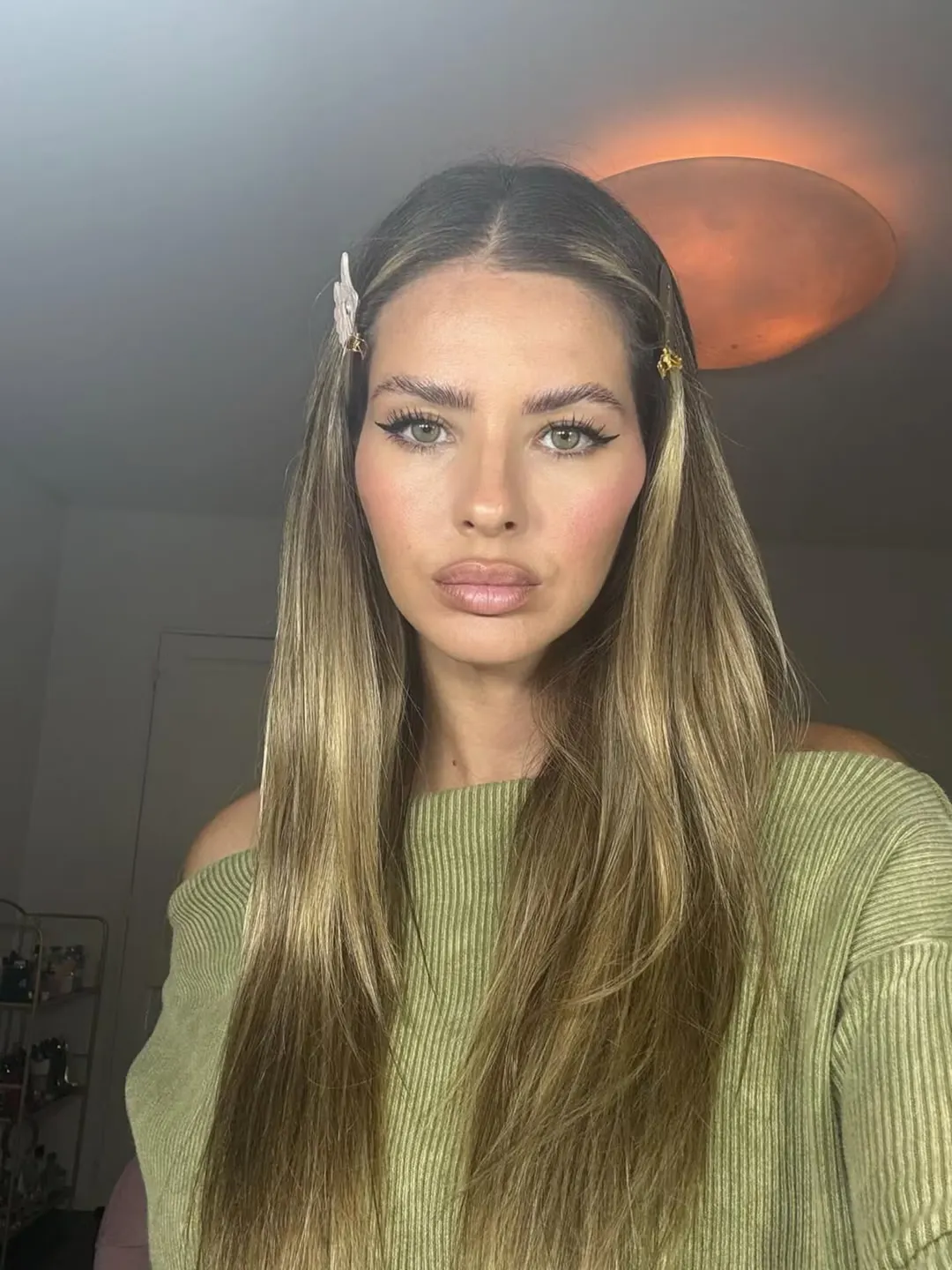 Con hebillas en el pelo y maquillaje glam.