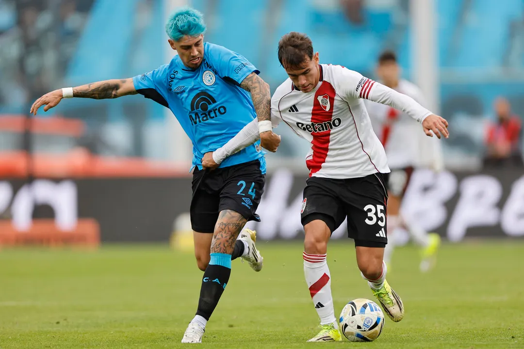 Joaquín Freitas, de River, disputa el balón con Emiliano Rigoni, mediocampista de Belgrano.