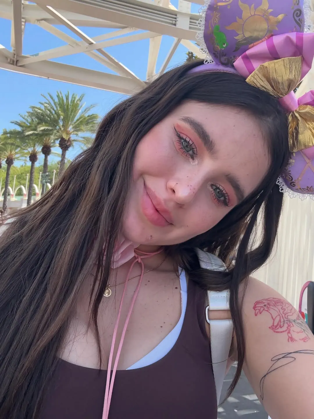 Coti Romero volvió a Disney con conjunto chocolate y flor rosa.