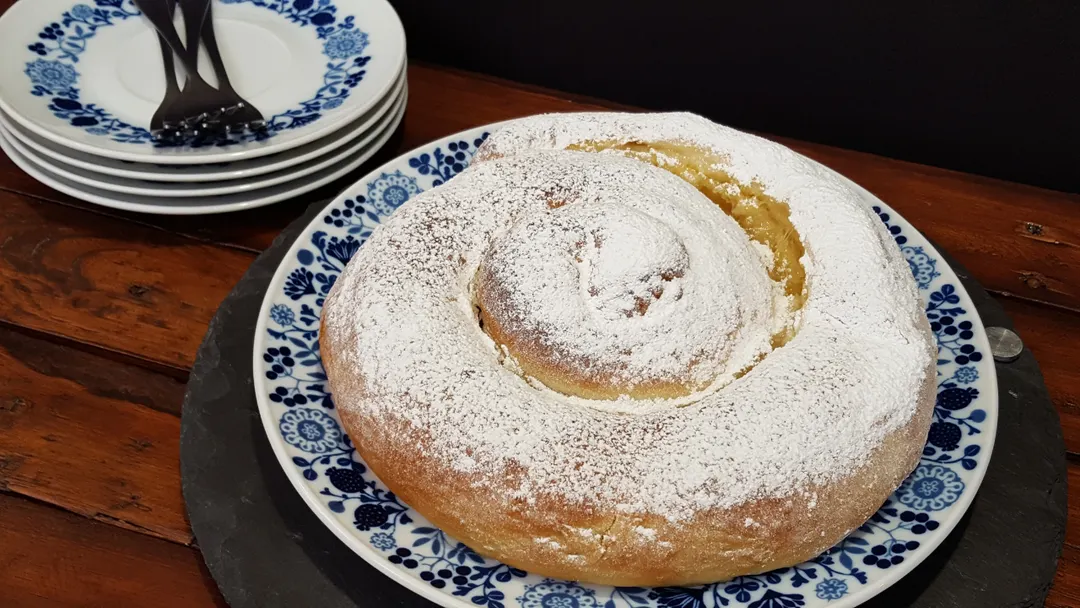 La receta de ensaimada suele espolvorearse con azúcar glass antes de servir.