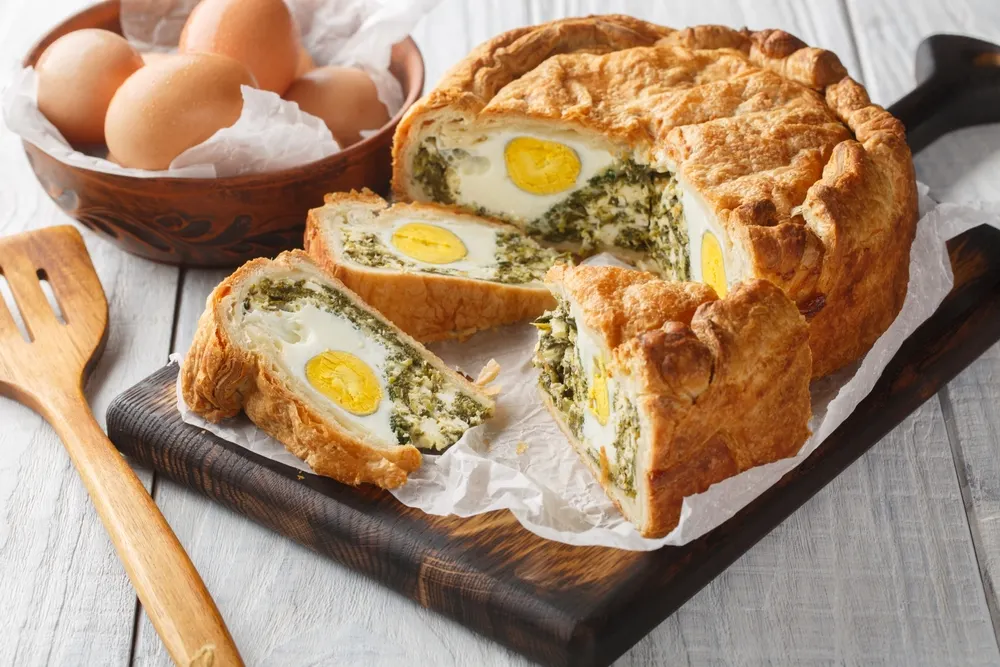 La receta de tarta pascualina suele incluir huevos enteros en el relleno, que se cuecen al hornearla.