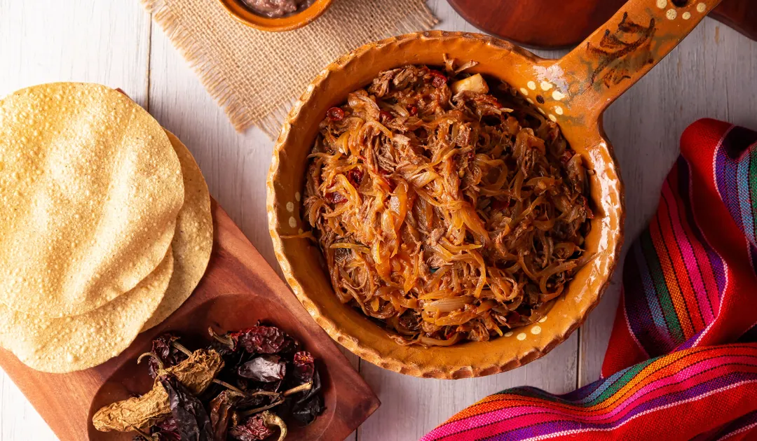 La receta de tinga de res tiene su origen en el estado de Puebla, donde se creó como una forma práctica de aprovechar la carne deshebrada sobrante, mezclándola con jitomate, chipotle y cebolla.